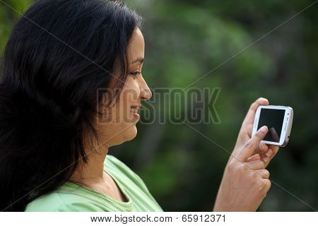 Happy Young Woman Text Messaging At Outdoors