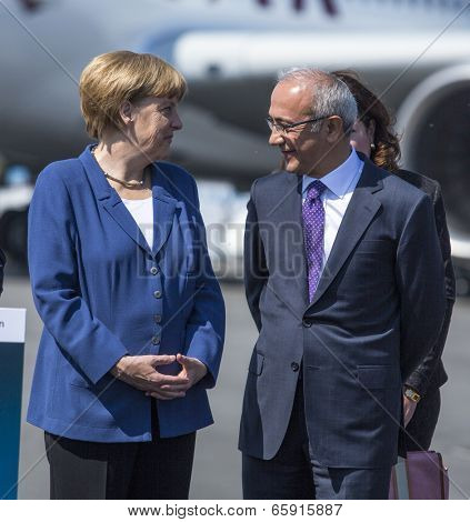 BERLIN, GERMANY - MAY 20, 2014: German Chancellor Angela Merkel (L), Turkish Minister of transport Lutfi Elvan (R) open up the International aviation and space exhibition ILA.