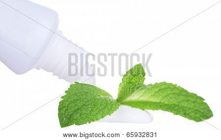 Toothpaste squeezed from tube, mint leaves, close-up, isolated on white