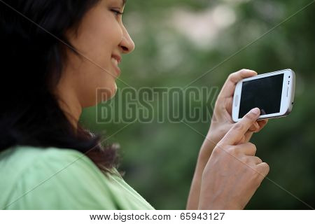 Happy Young Woman Text Messaging At Outdoors
