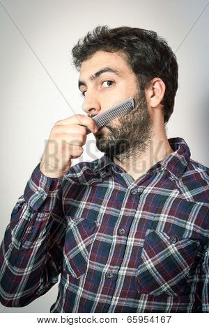 young man want comb his beard and moustaches