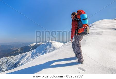 Hiker girl with backpack  in a high mountains
