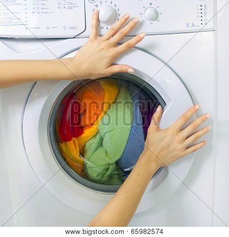 Woman Loading Clothes In The Washing Machine