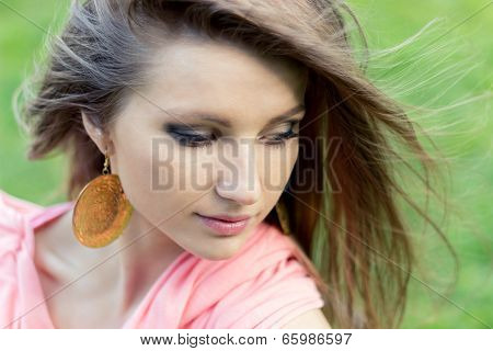 beautiful elegant young girl sitting in the Park and the wind in your hair