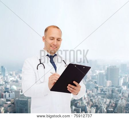 medicine, profession, urrban life and healthcare concept - smiling male doctor with clipboard and stethoscope writing prescription over city background