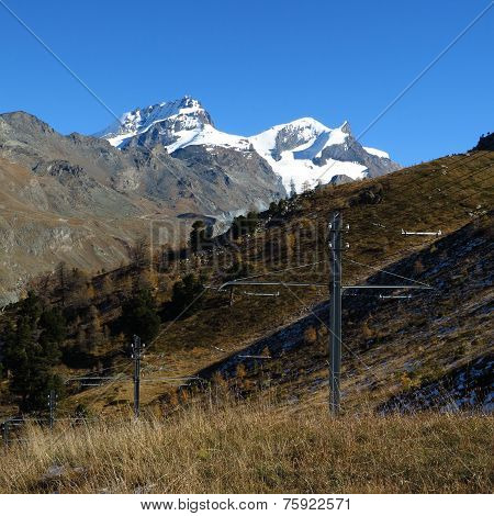 Snow Capped Mountains And Power Poles Of The Train To The Gornergrat