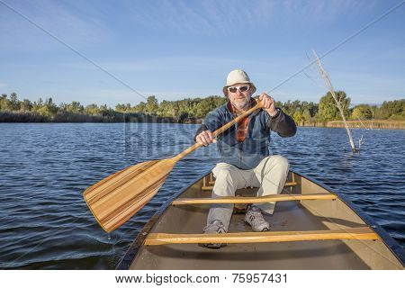 senior male enjoying morning sun on a lake in a canoe, Riverbend Ponds Natural Area, Fort Collins, Colorado