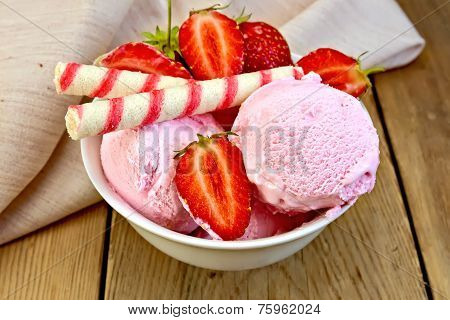 Ice cream strawberry in bowl with wafer rolls on board