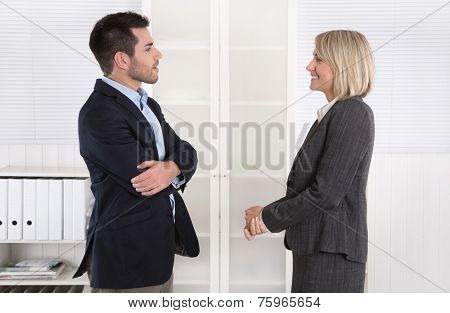 Business people in suit and dress talking together: small talk.