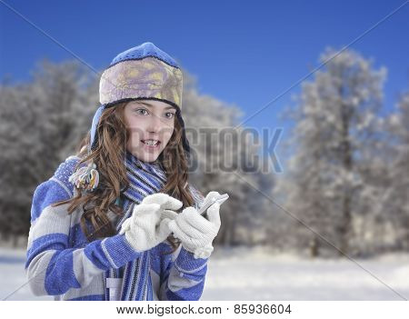 Girl in winter clothing with smartphone