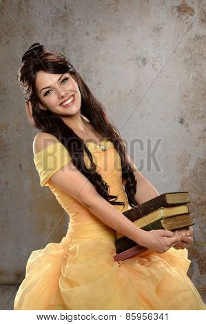 Young  woman dressed in princess costume holding books in old room