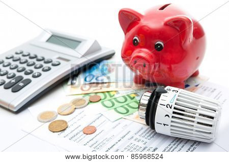Heating thermostat with piggy bank and money, expensive heating costs concept