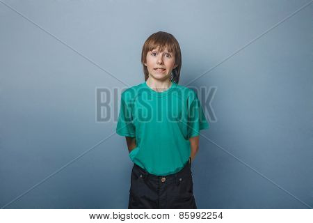 Boy , teenager,  twelve years in green T-shirt , showing teeth