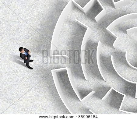 Top view of successful businessman standing near the entrance of labyrinth