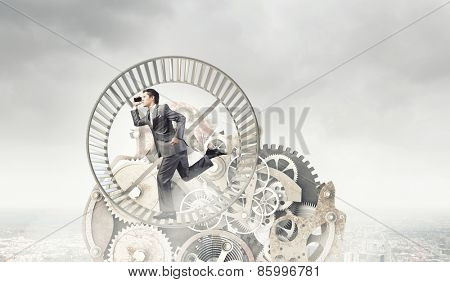Young businessman in suit running in hamster wheel