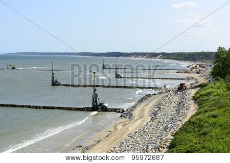 USTKA - JULY 07: Workers build a breakwater to facilitate the construction of the beach on 7 July 2015 in Ustka, Poland.