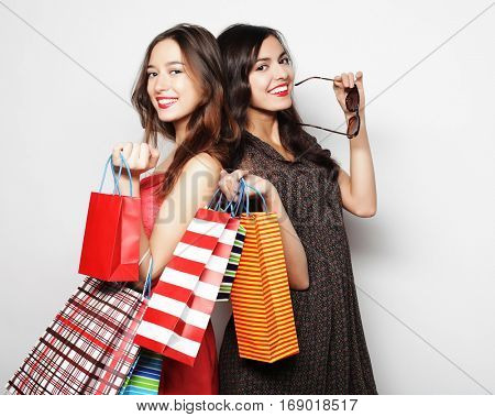 Beautiful  teen girls carrying shopping bags, over white backgro