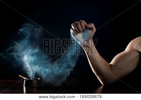 stop smoking concept. Human hand is struggling with a hand of smoke