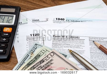 Tax Form W4, 1040, 1120 With Pen And Us Dollar
