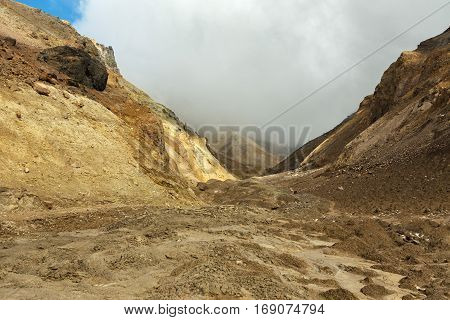 Beautiful scenery slopes of the volcano Mutnovsky with clouds.