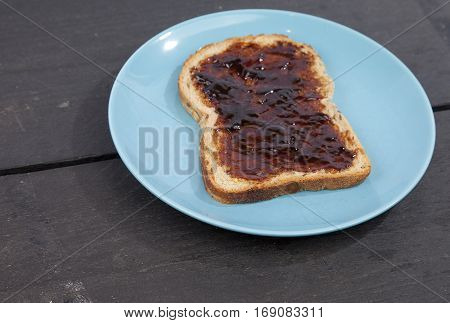 Typical Dutch apple syrup called Appelstroop on bread on wooden background