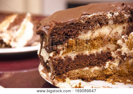 Sliced layered chocolate cake with chocolate icing on a plate