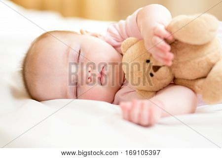 infant baby girl sleeping with plush toy