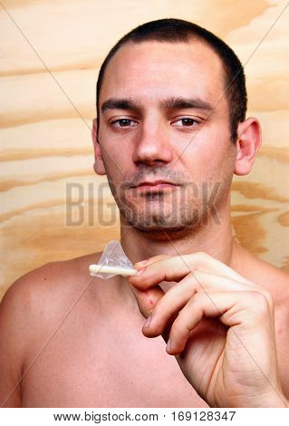 Young Handsome Man Shows And Keeps A Condom