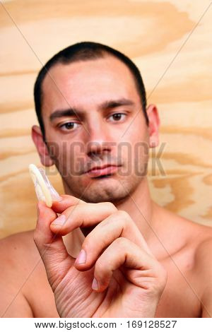 Young Handsome Boy Shows And Keeps A Condom
