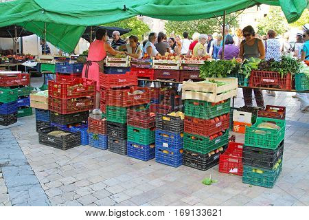 Besalu Spain - September 09 2014: Sale of fruit and vegetables in street of Besalu in Spain. Fruit and vegetables in plastic and wooden boxes at farm market.