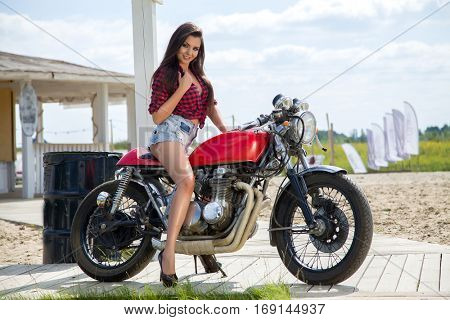 Biker Girl on Retro Motorcycle - Portrait of a cool woman on a vintage motorbike