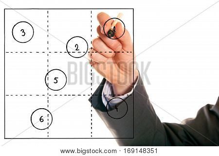 businessman drawing a generic 3x3 portfolio, a tool often used in various decision making and analysis processes.