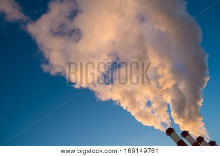 environmental pollution concept, pipes and smog on blue sky background