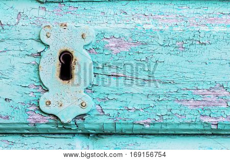 Beautiful old vintage rustic cracked turquoise paint wooden door and rusty iron lock and keyhole as a background