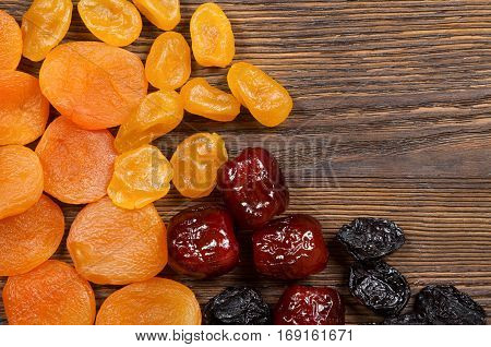 Dried fruits on a wooden background. Apricots dates lemons and plums.
