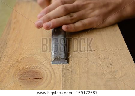 Carpentry working with chisels a wooden board - close-up