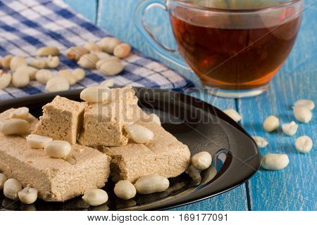 peanut halva in the plate on a blue wooden background.