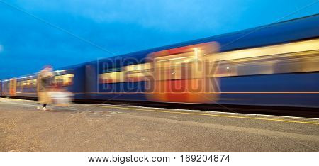Train departing a UK station and gathering speed