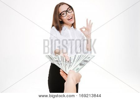 Smiling happy business woman accepting money offering or bribe isolated on white
