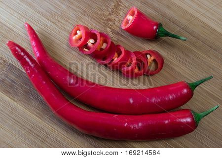 Red chili pepper cutting slieces on bamboo board