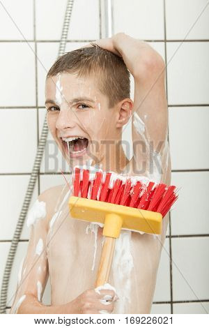 Young Boy With Broom Brush In The Shower