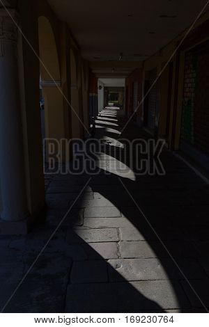 Under the arcades in the shade between the arches of the country of Brescello.