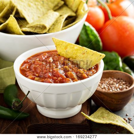 Red tomato spicy salsa with green torltilla corn chips