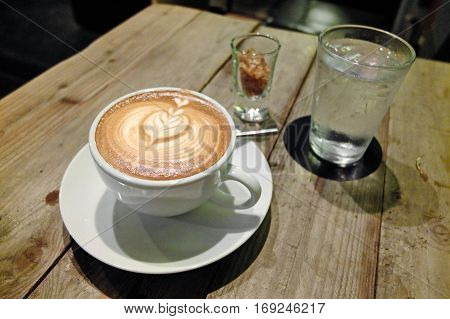Coffee with latte art on the cafe table