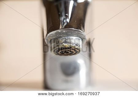 Hard water calcium deposit on chrome tap