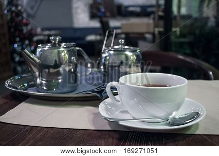 Teapot and cups are prepared for tea drinking in cafe