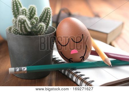 Egg With Sleeping Face On Work Desk Relaxing And Sleep From Hard Working Concept.
