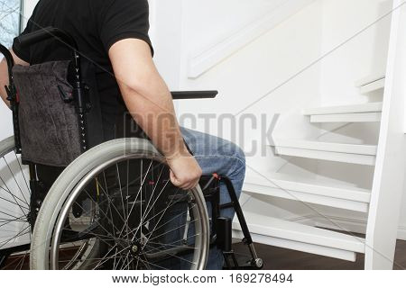  Empty wheelchair and stairs. Disabled accessibility reality