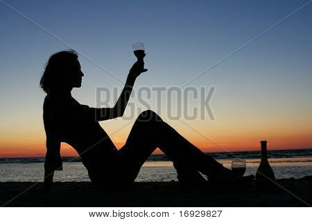 niña bebiendo vino en la playa