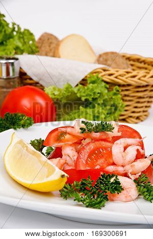 Salad with shrimp and tomatoes on a white plate with a serving